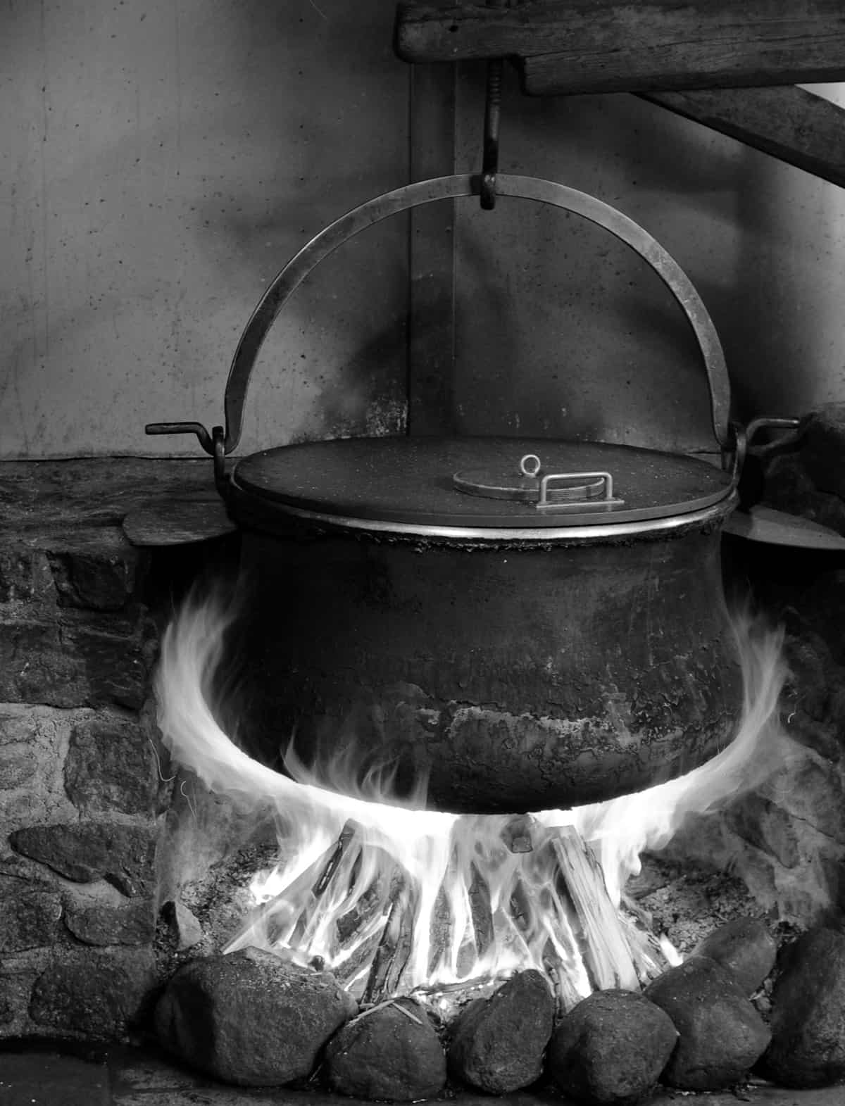 Kessel hängt über Feuer, schwarz-weiß